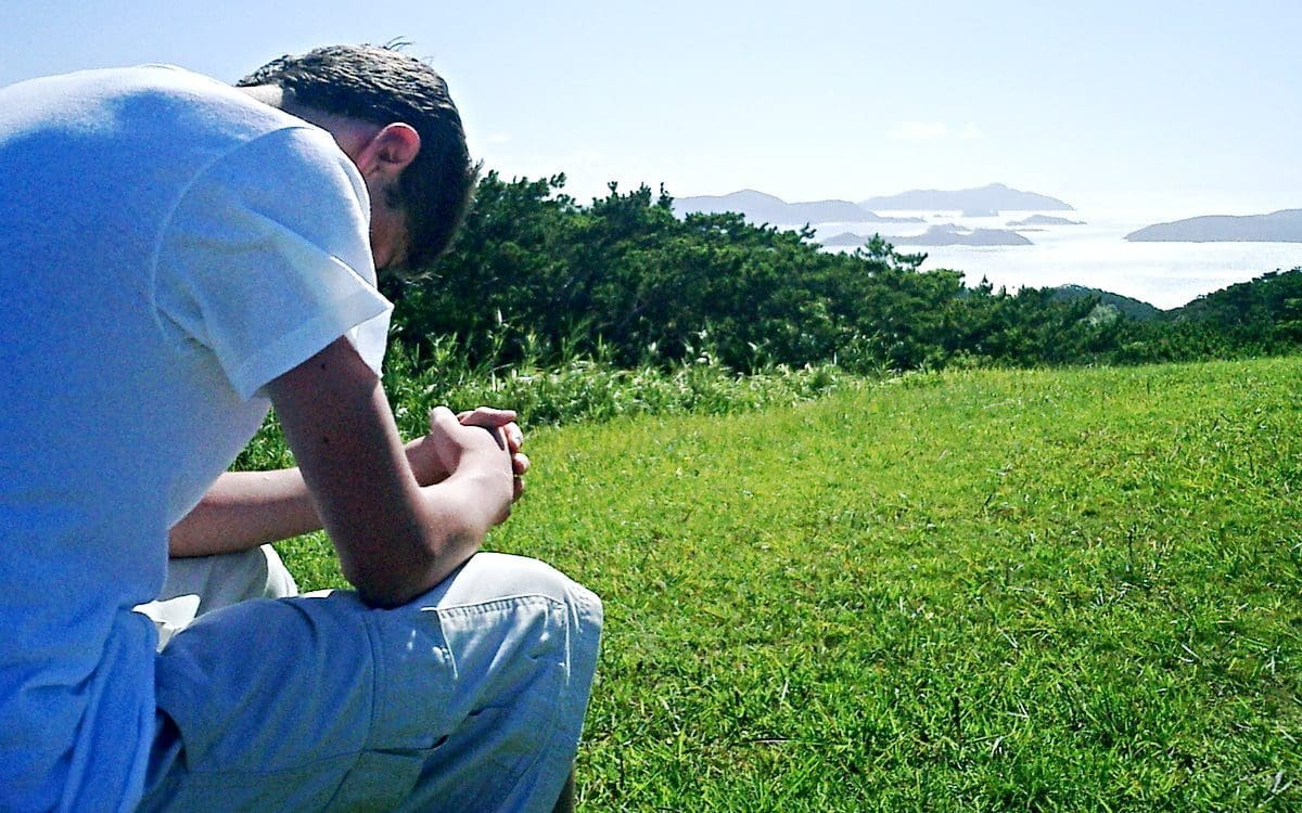 Young man praying outdoors