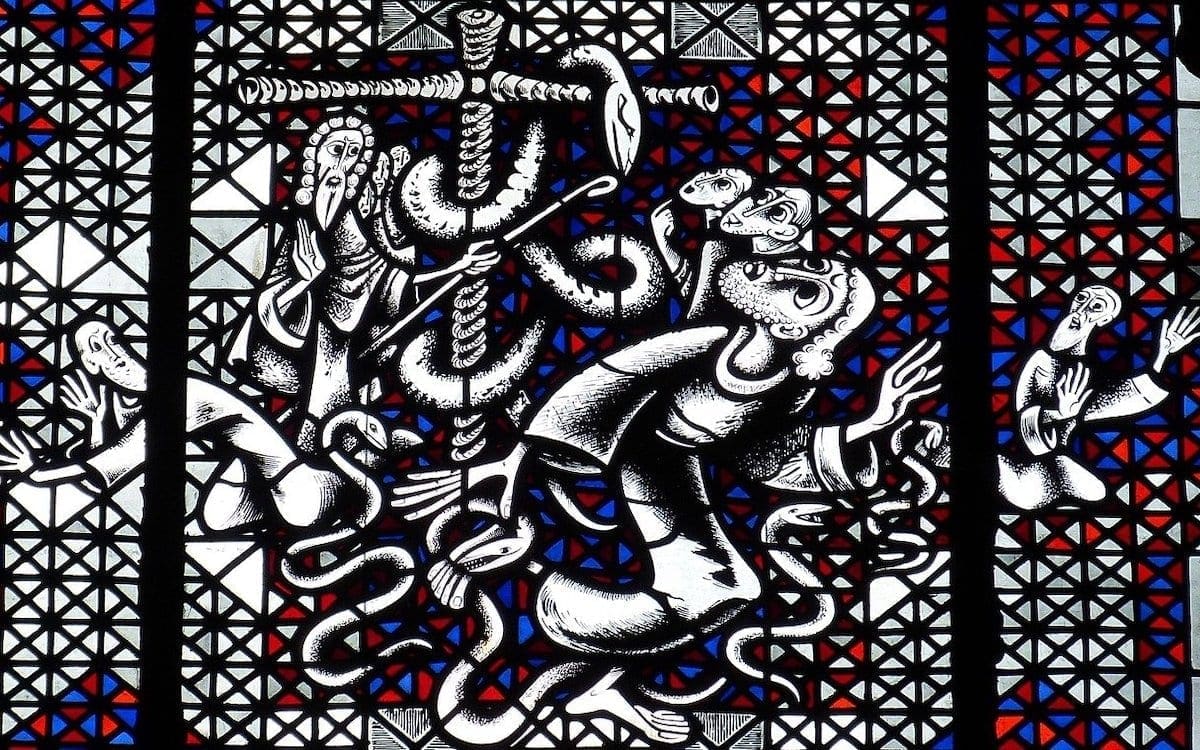 A stained glass window depicting the story in Numbers 21 when Moses creates a bronze serpent and places it on a pole.