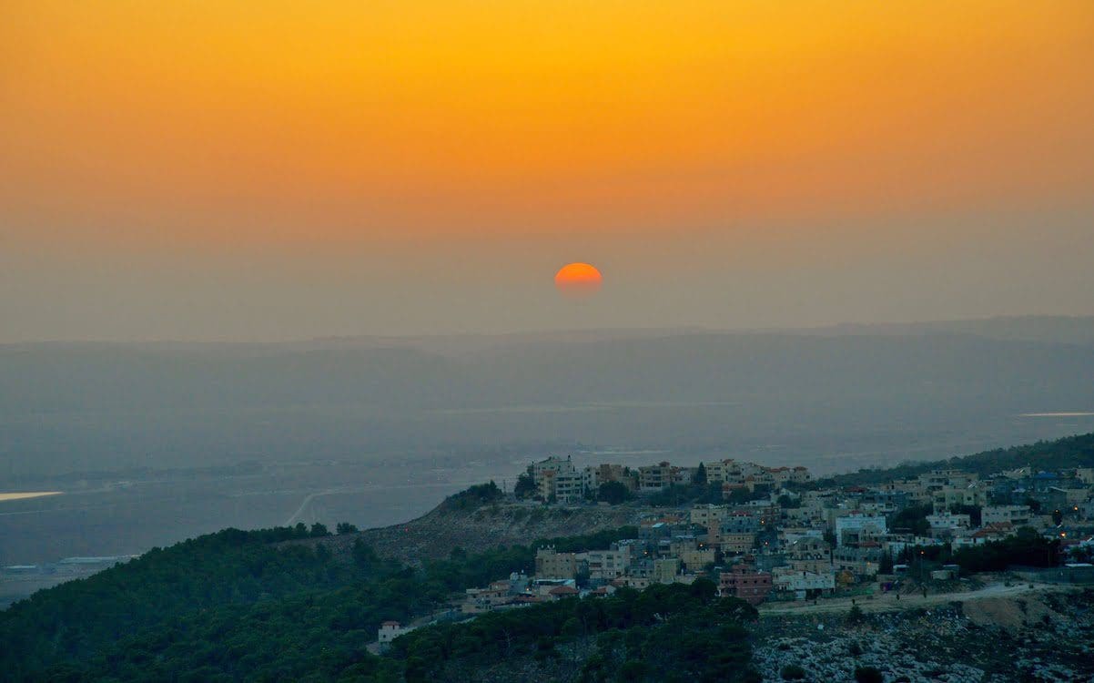 The sun setting over a sitting with an orange sky.
