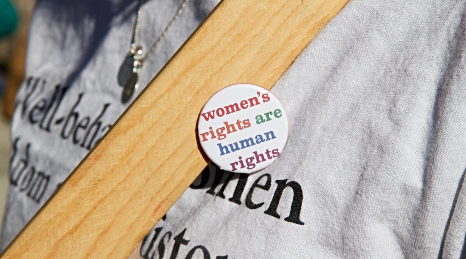 A woman wearing a button that says women's rights are human rights
