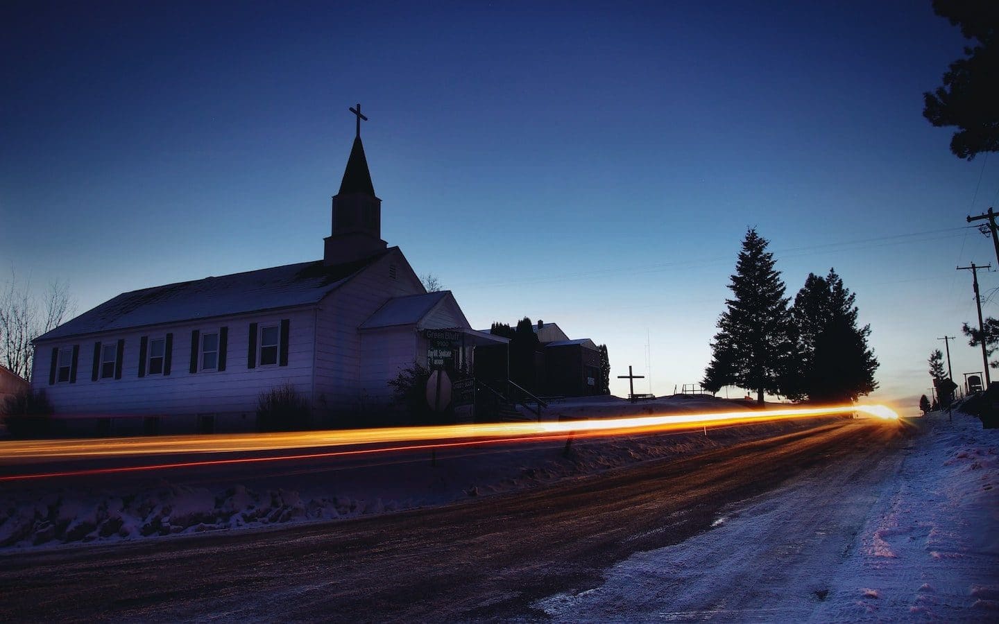 A rural church seen from the road in the early morning just before sunrise