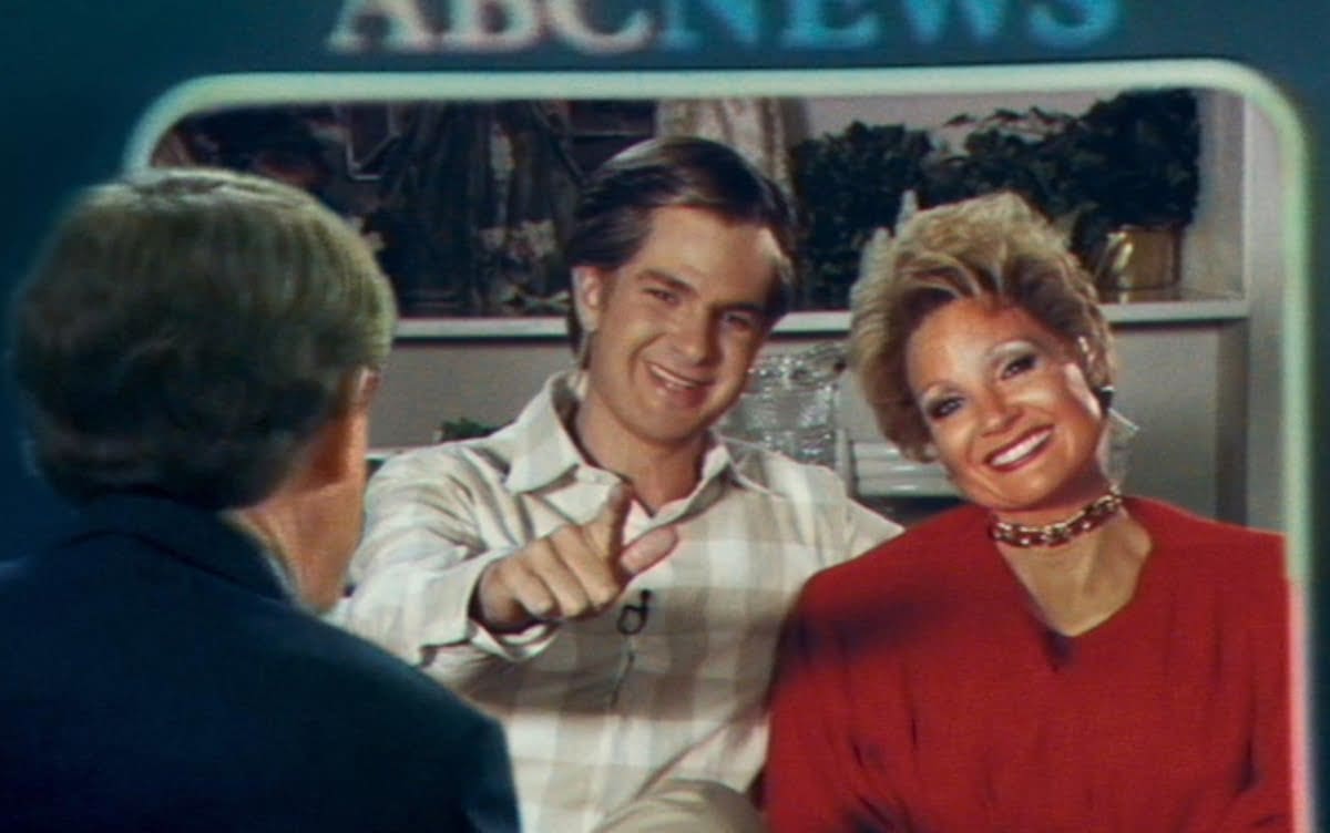 A couple smiling during a television interview.