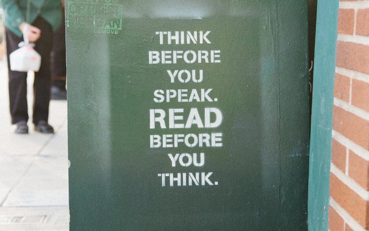 A green book cart with “Think Before You Speak. Read Before You Think” written on the side.