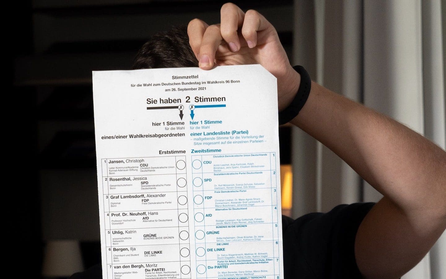 A person holding up a voting ballot.