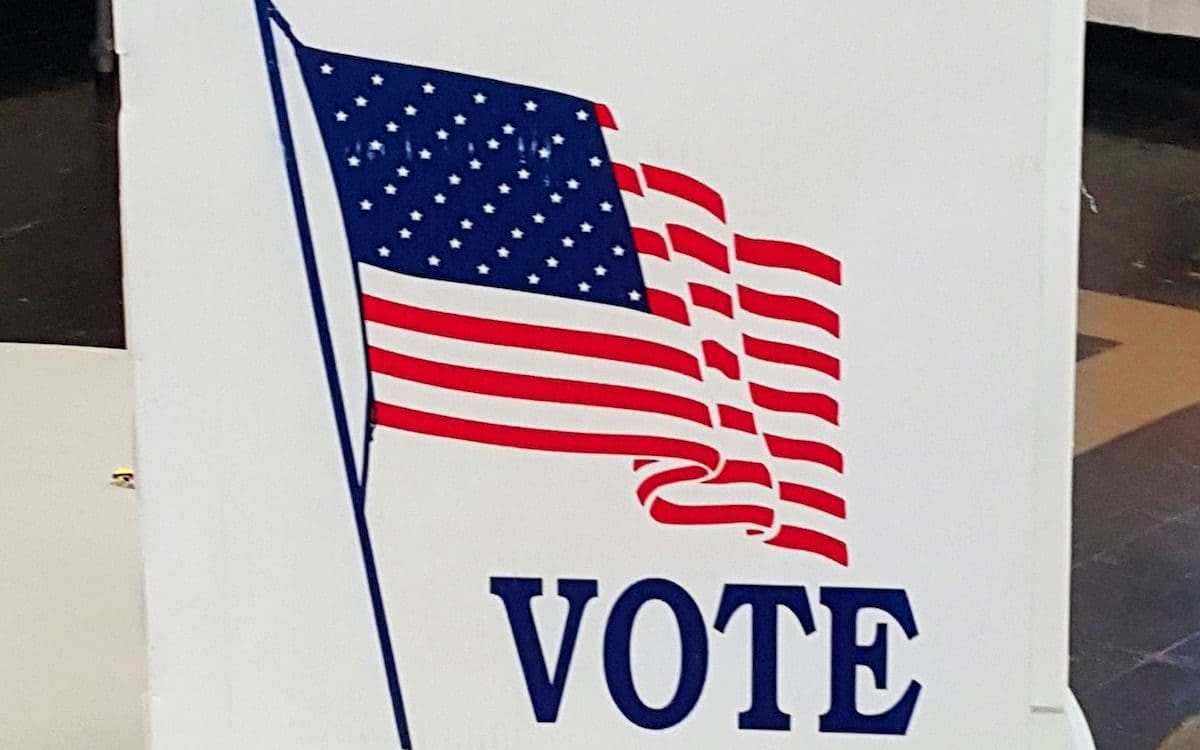 A voting booth with a U.S. flag on the side.