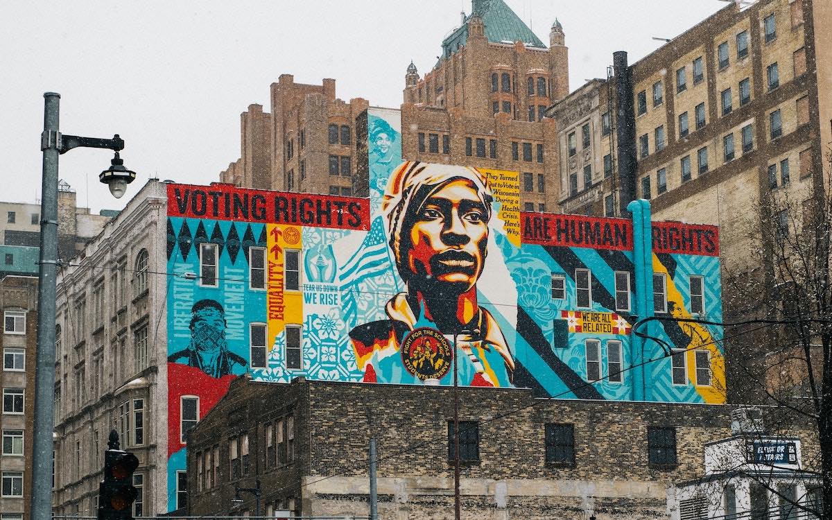 A mural on the side of a building with the words