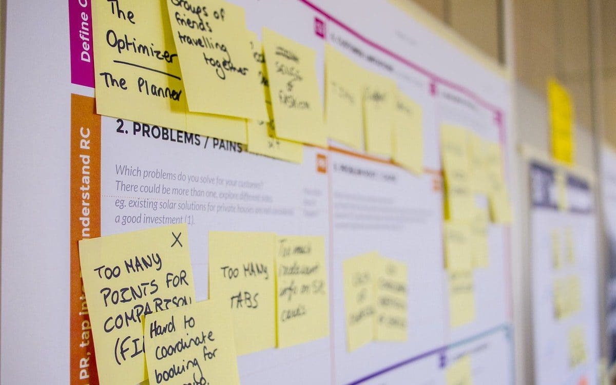 A large wall calendar with post-it notes all over it.