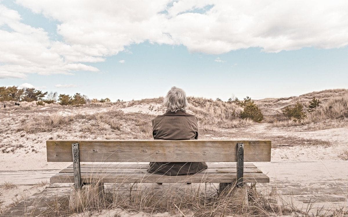 Elderly woman sitting on outdoor bench