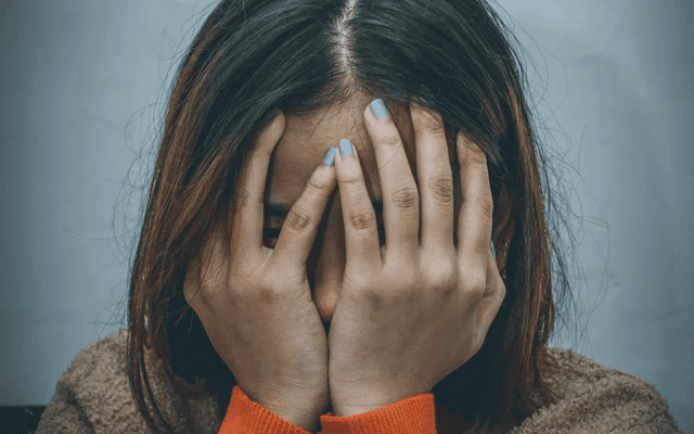 Woman with face in hands.|Woman with face in hands.