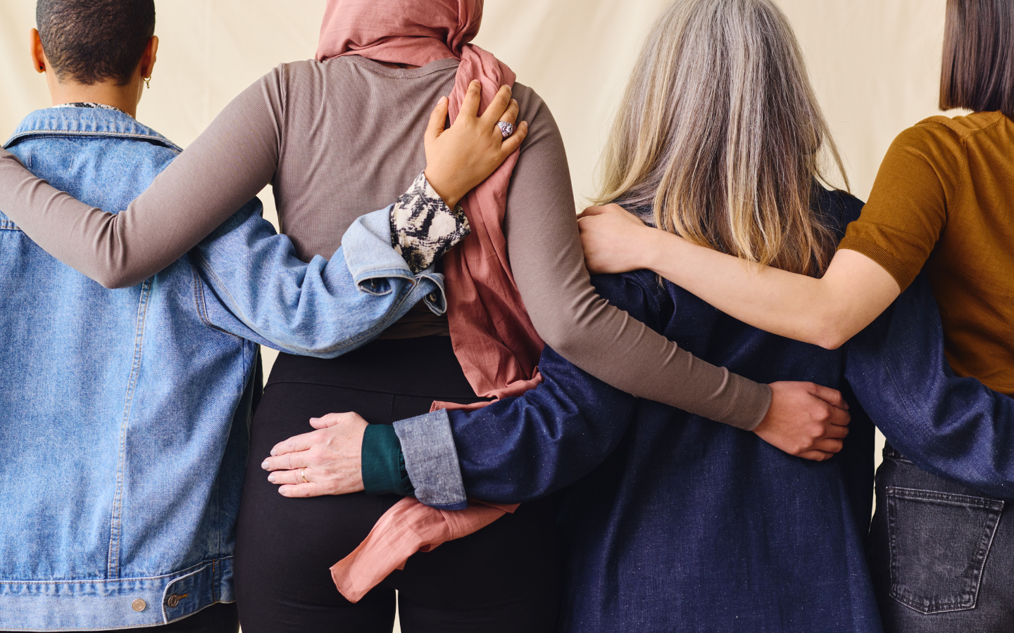 A rear portrait of people standing shoulder-to-shoulder.