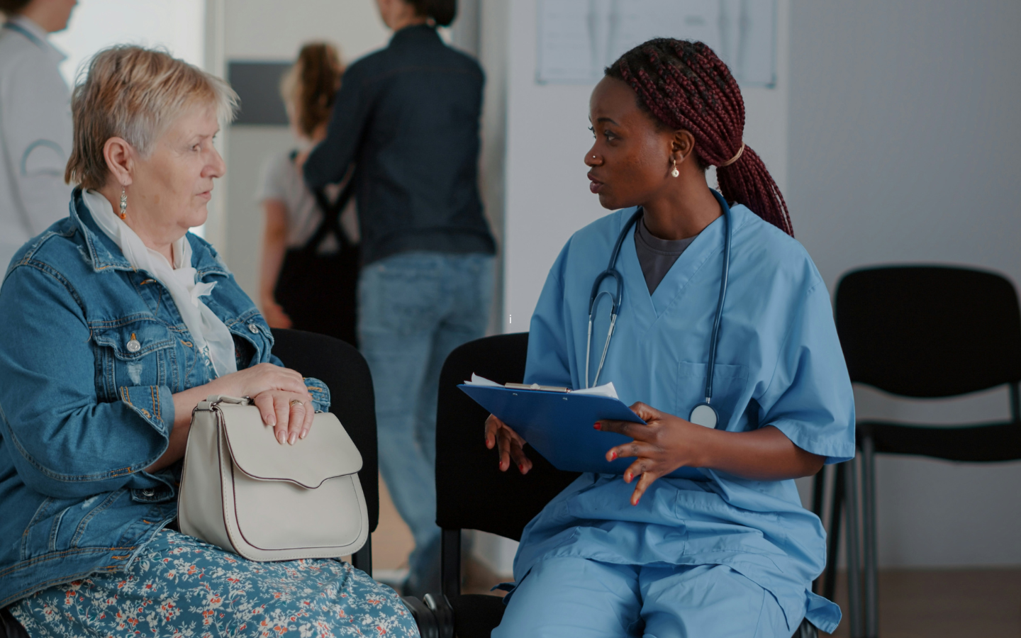 A doctor consults with her patient in a waiting room.