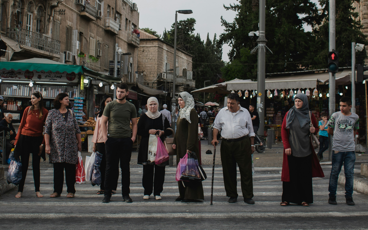 A group of Palestinians stand at a crosswalk near the Damascus Gate in Jerusalem.
