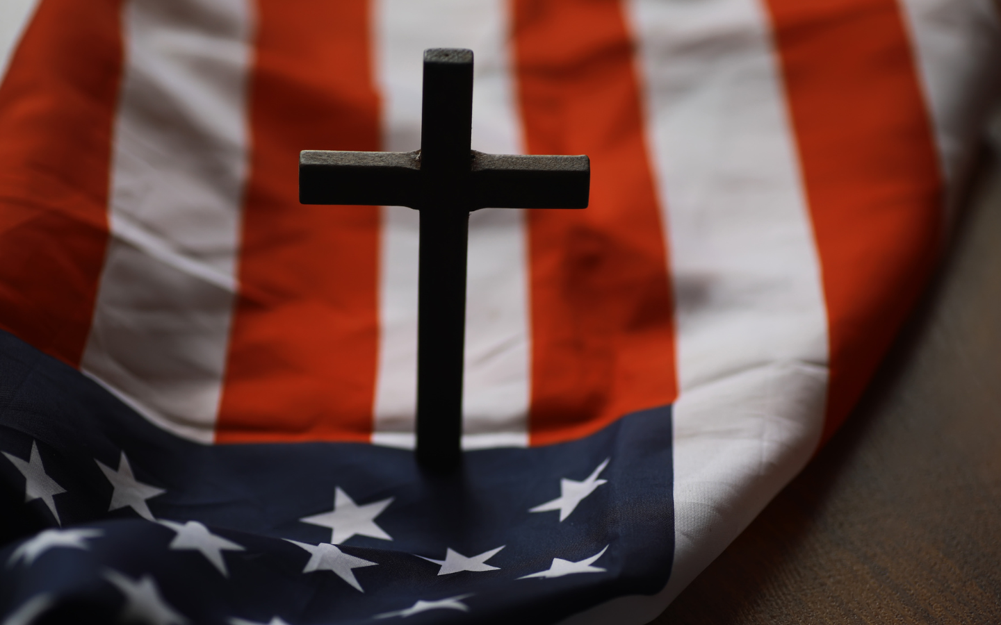 A cross on top of an American flag.