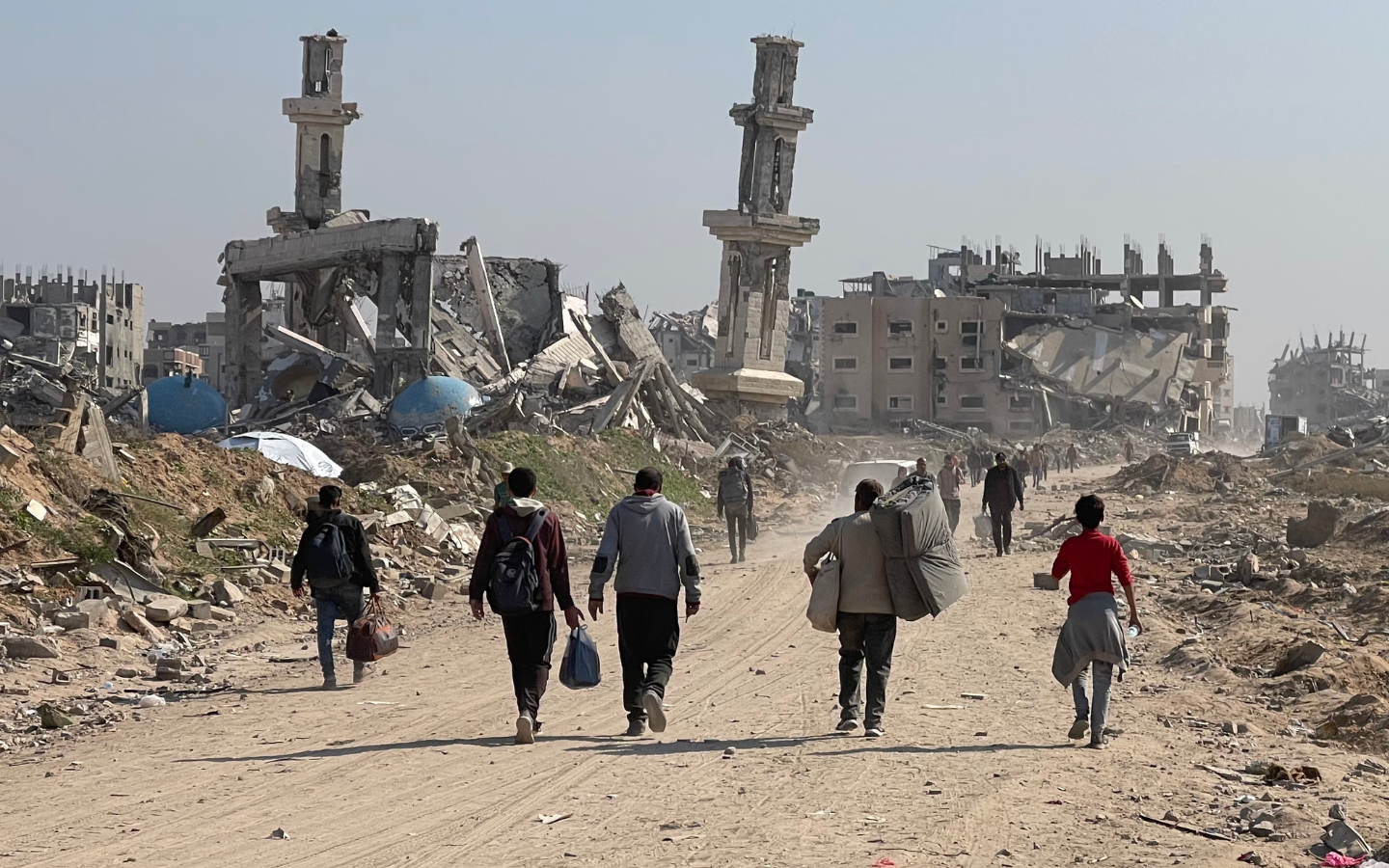 Residents of Gaza in search of humanitarian aid walk among the ruins of their city.