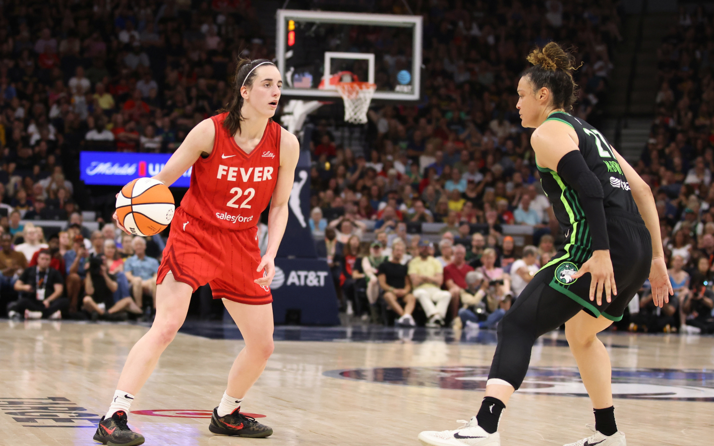 An image of the Indiana Fever’s Caitlin Clark going up against the Minnesota Lynx’s Kayla McBride.