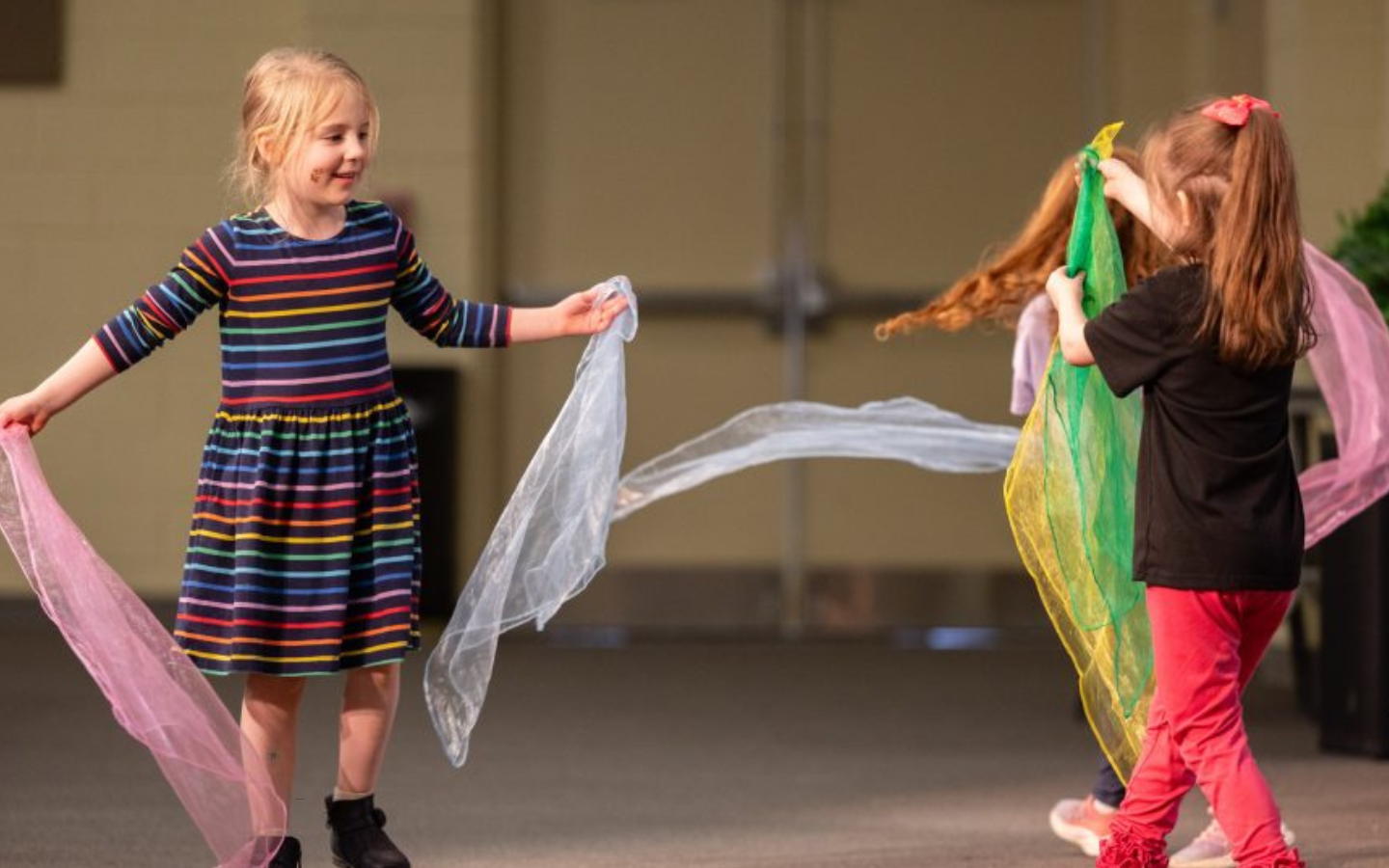 Two girls dance with scarves in an accessible worship service.