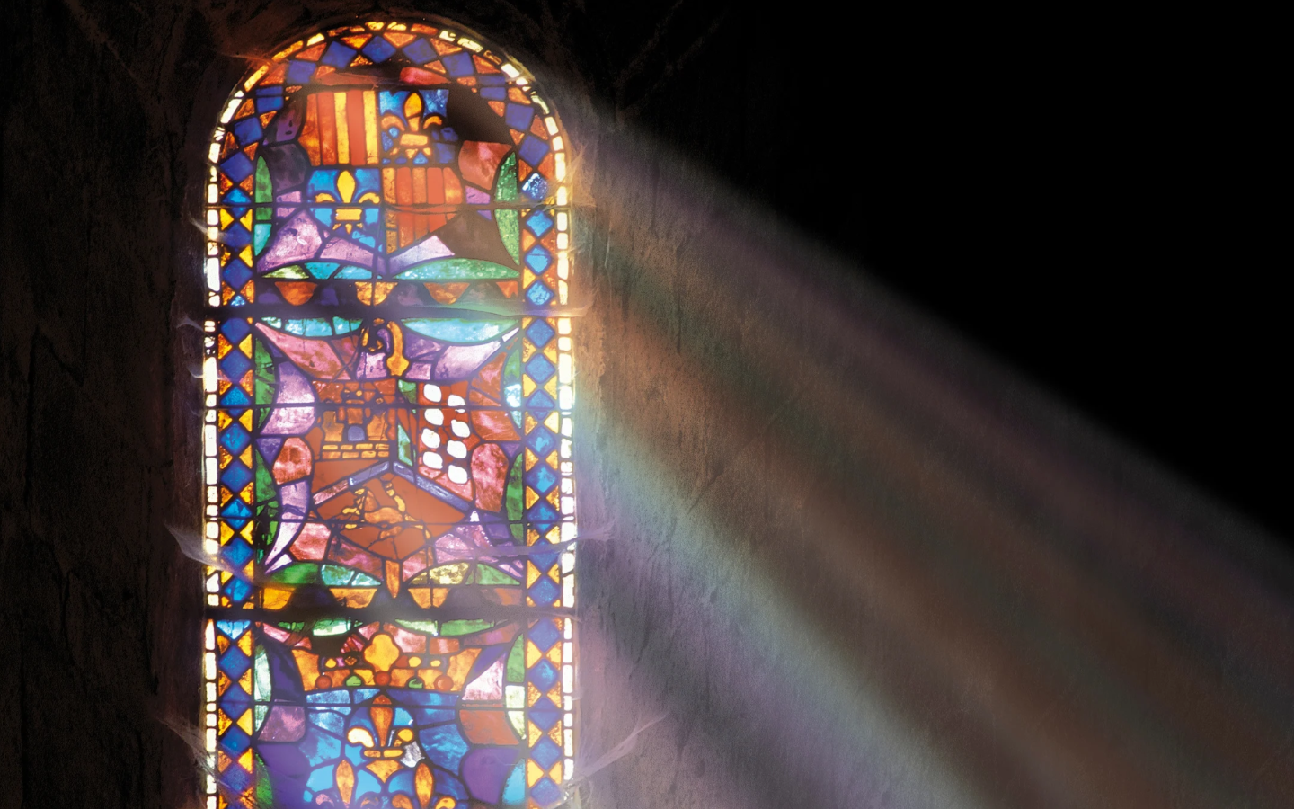 Sunlight coming through a church’s stained glass window.