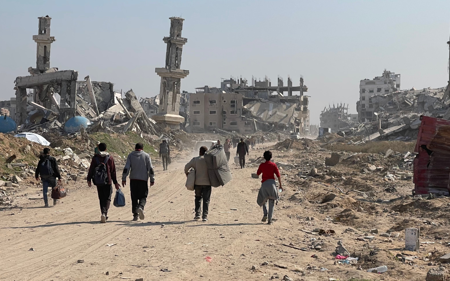 A crowd walks through the rubble in Gaza.