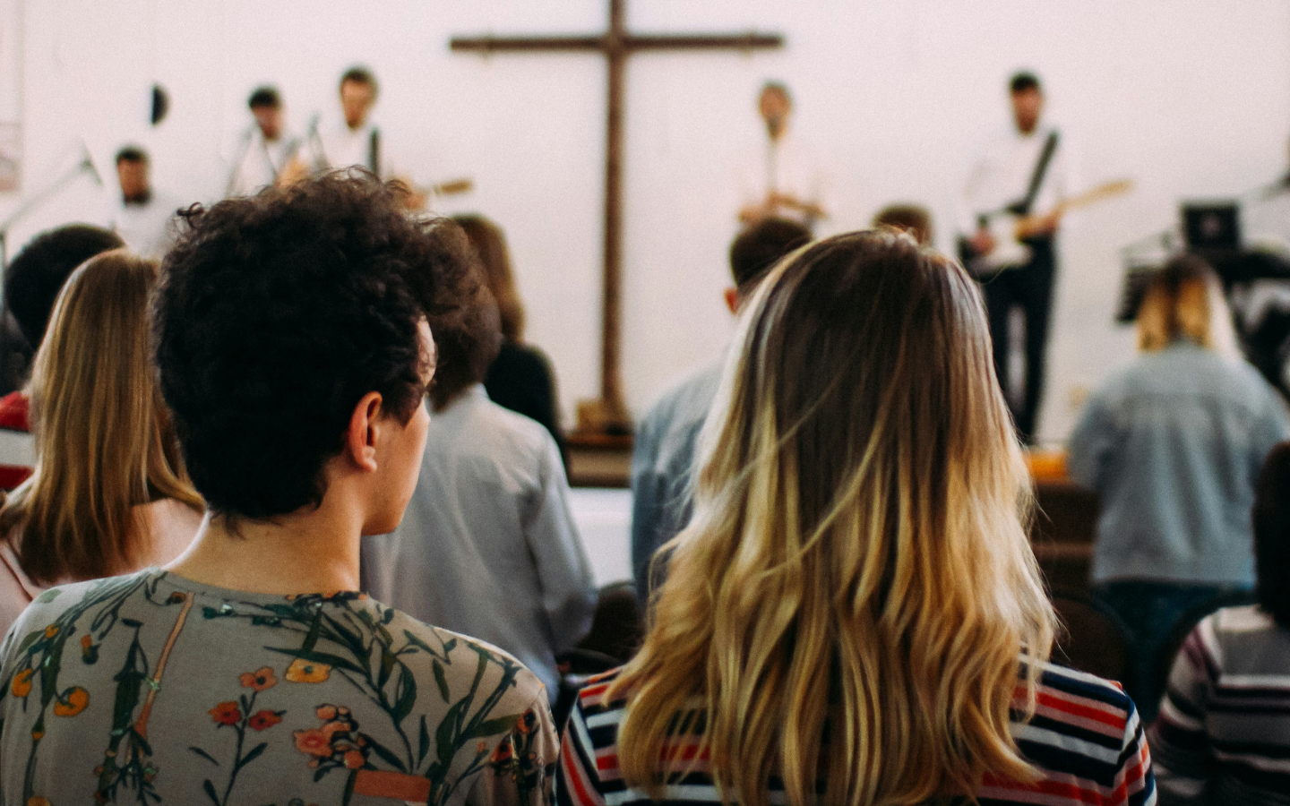 Young adults sitting in church pews during a worship service.