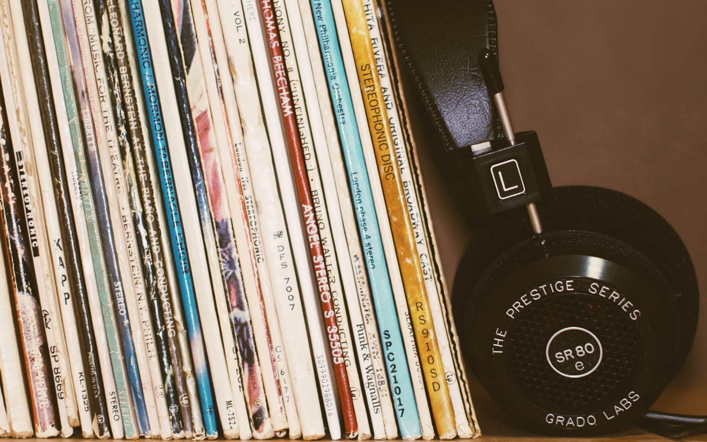 Stacks of vinyl records next to headphones.