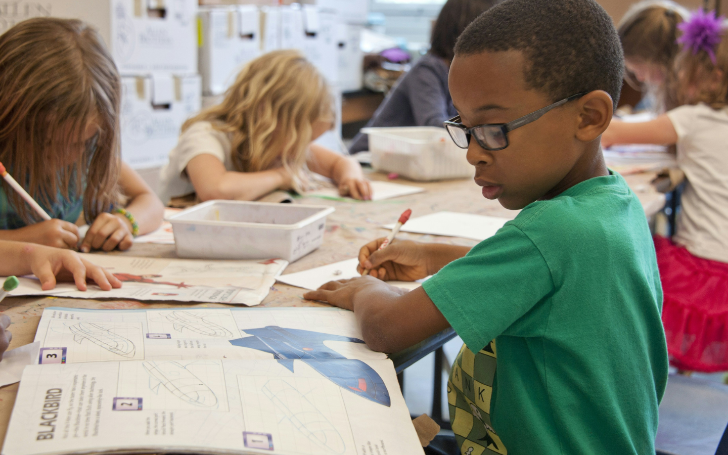 A classroom of schoolchildren work on a class project.