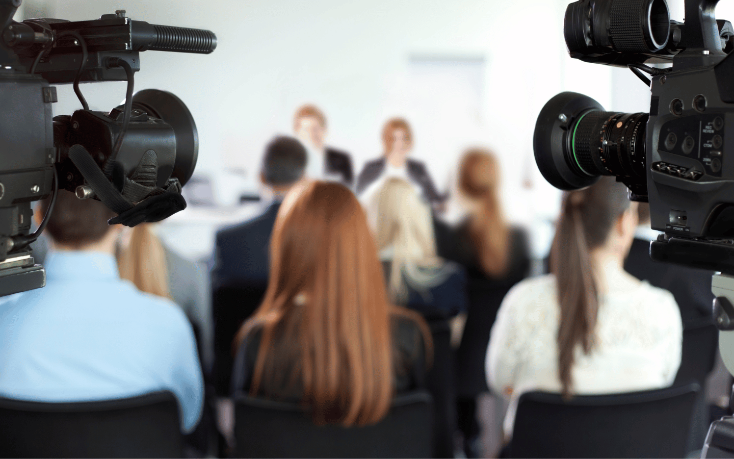 A press room with blurred images of the subjects.
