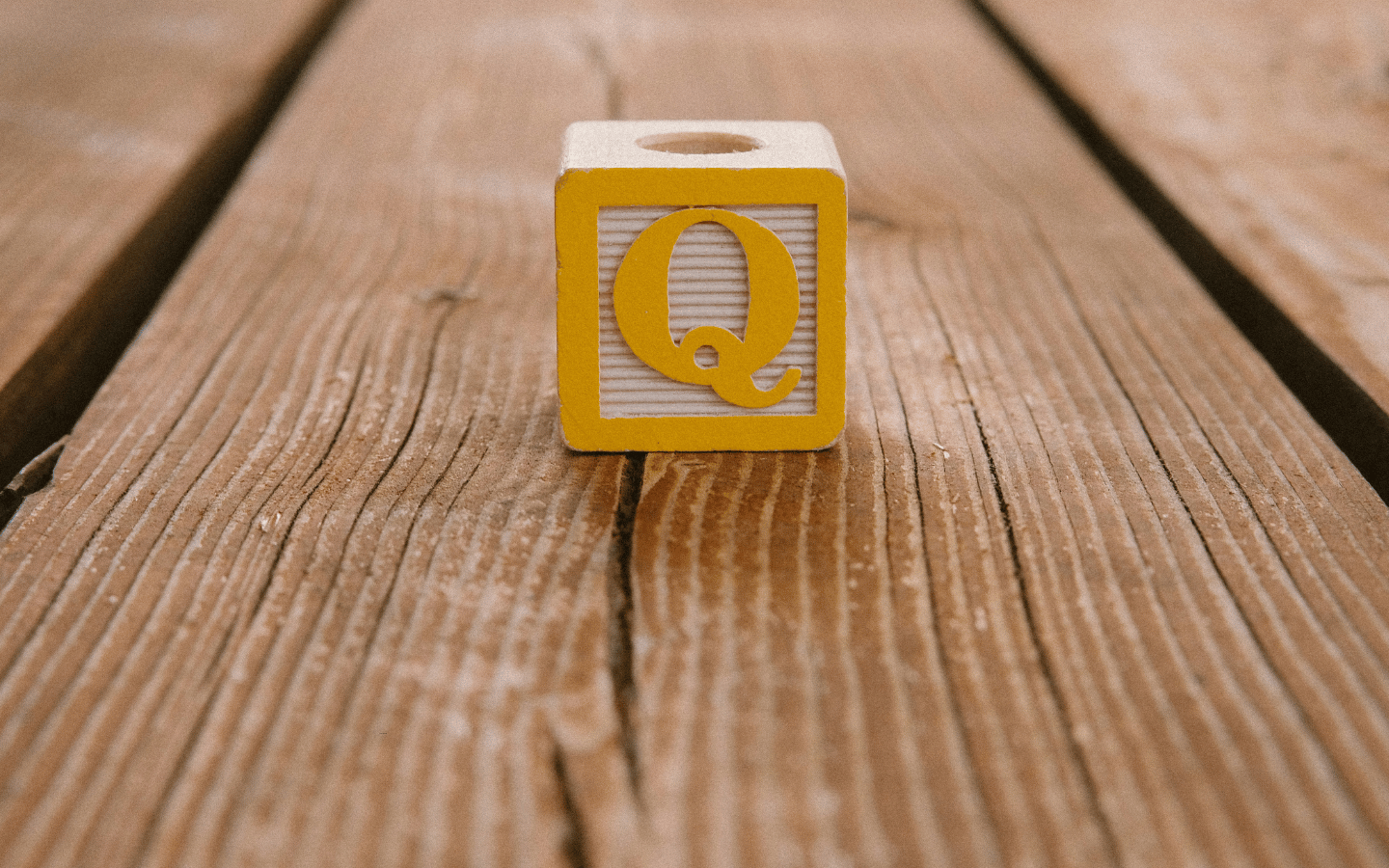 A yellow toy “Q” alphabet block.