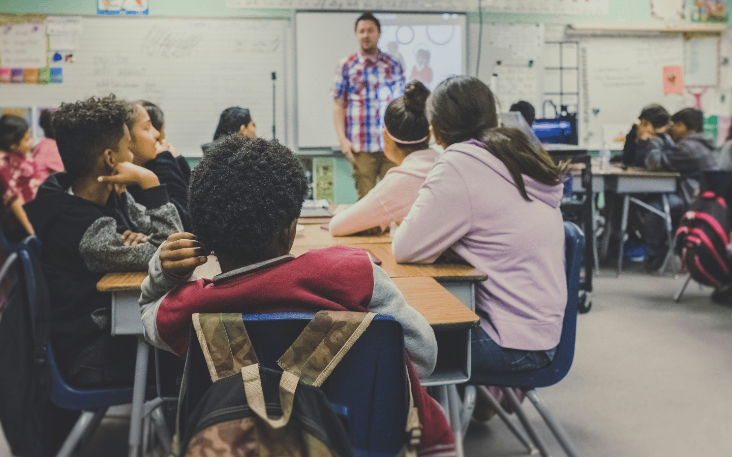 Students and a teacher in an elementary school classroom.