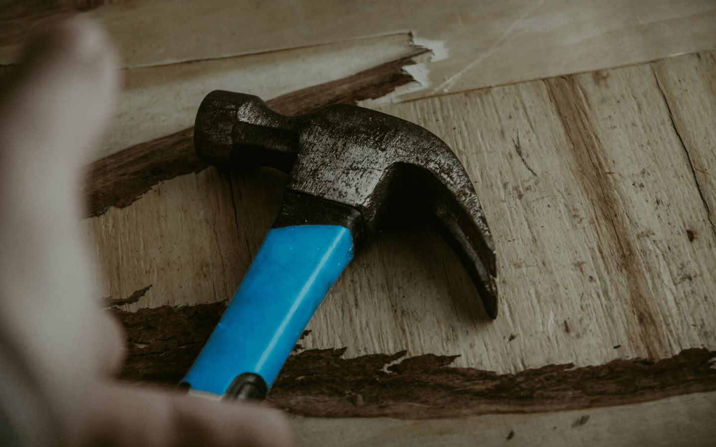A hammer lies on a piece of wood.