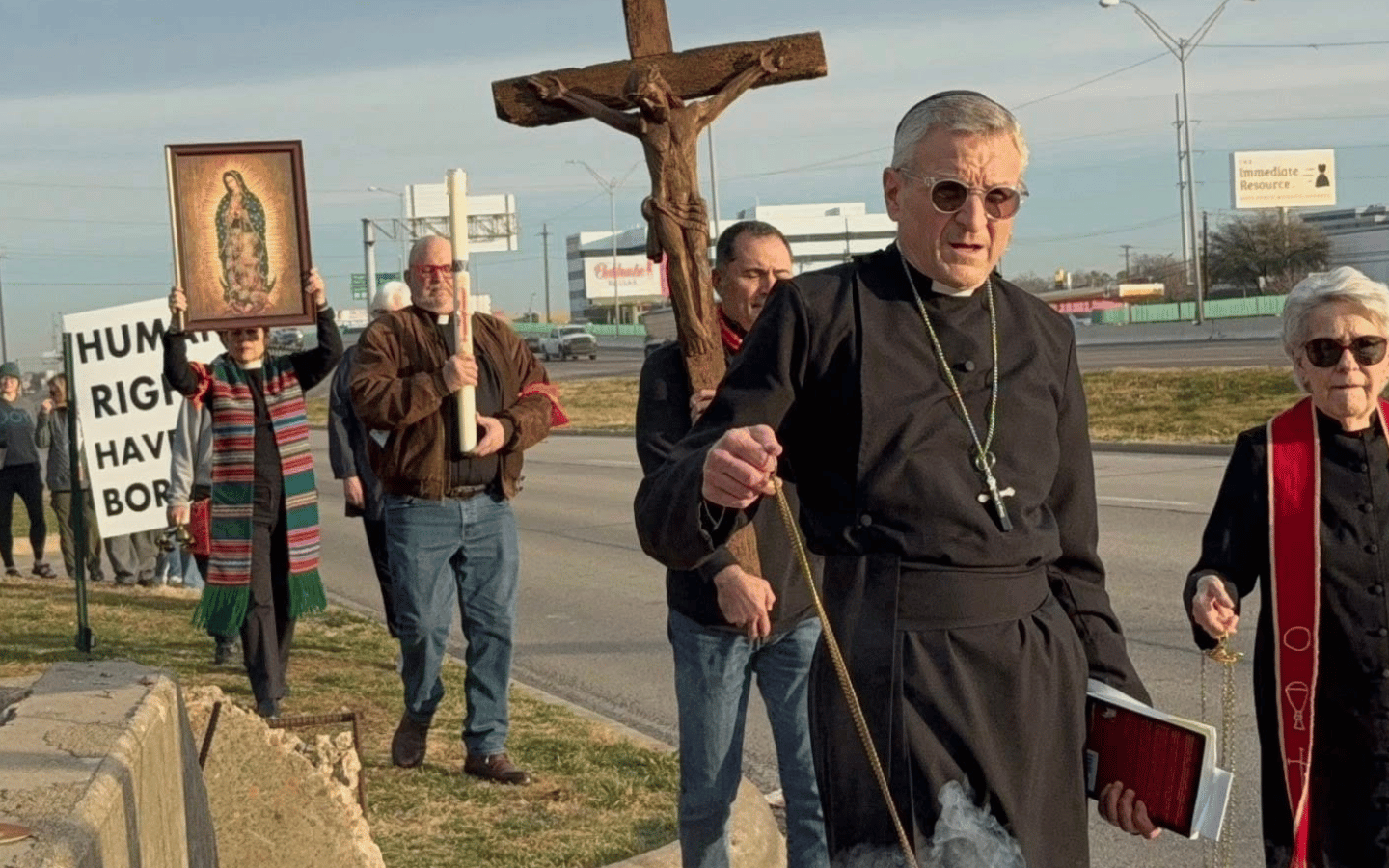 An Episcopal priest leads the February 9 vigil for peace at a Dallas ICE processing center.