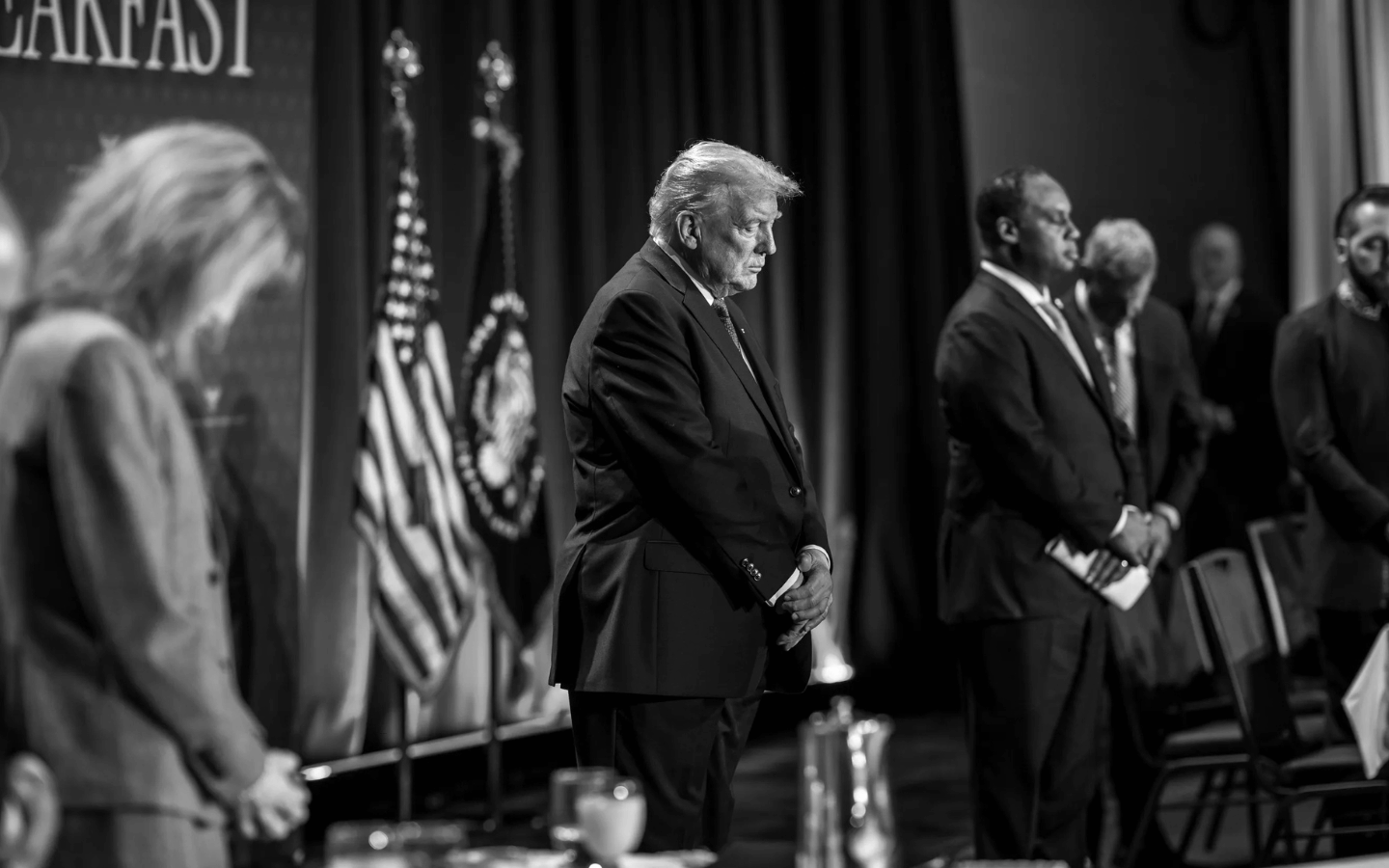 Donald Trump bows his head in prayer at the 2026 National Prayer Breakfast.