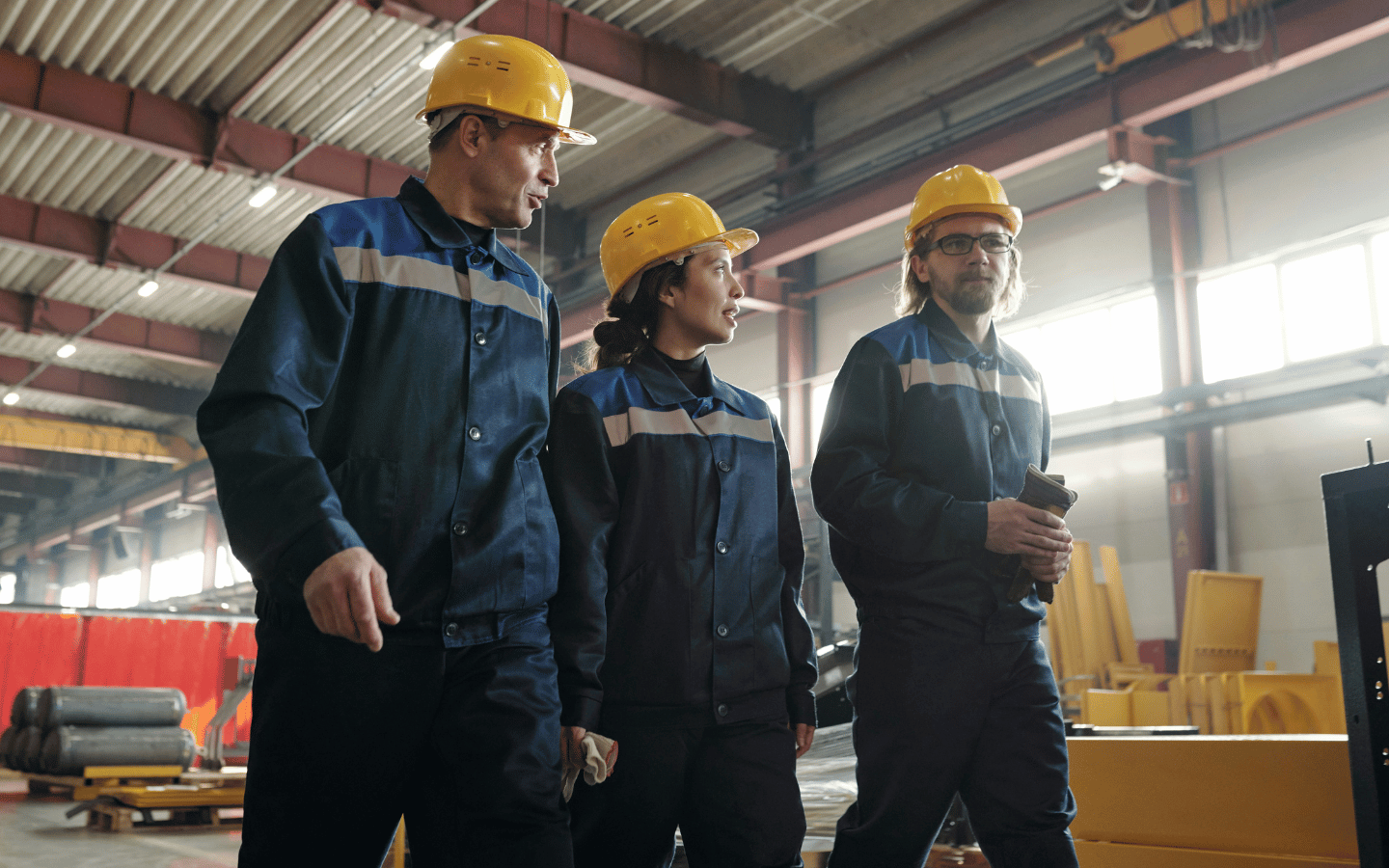 Three factory workers walking together.