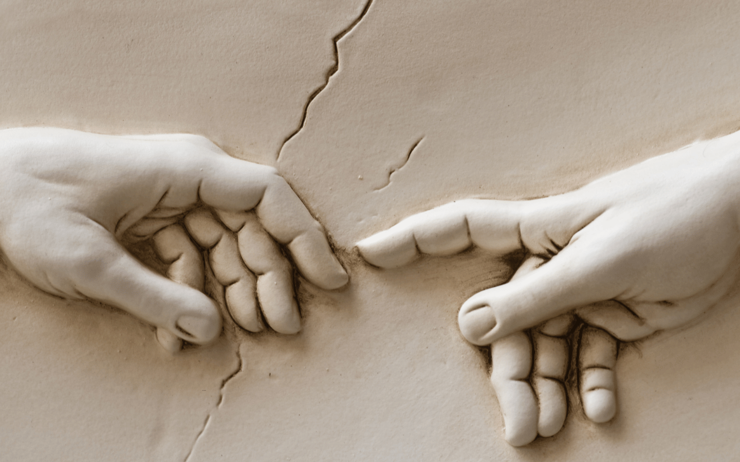 A close-up image depicting Michelangelo's God and Adam touching fingers.