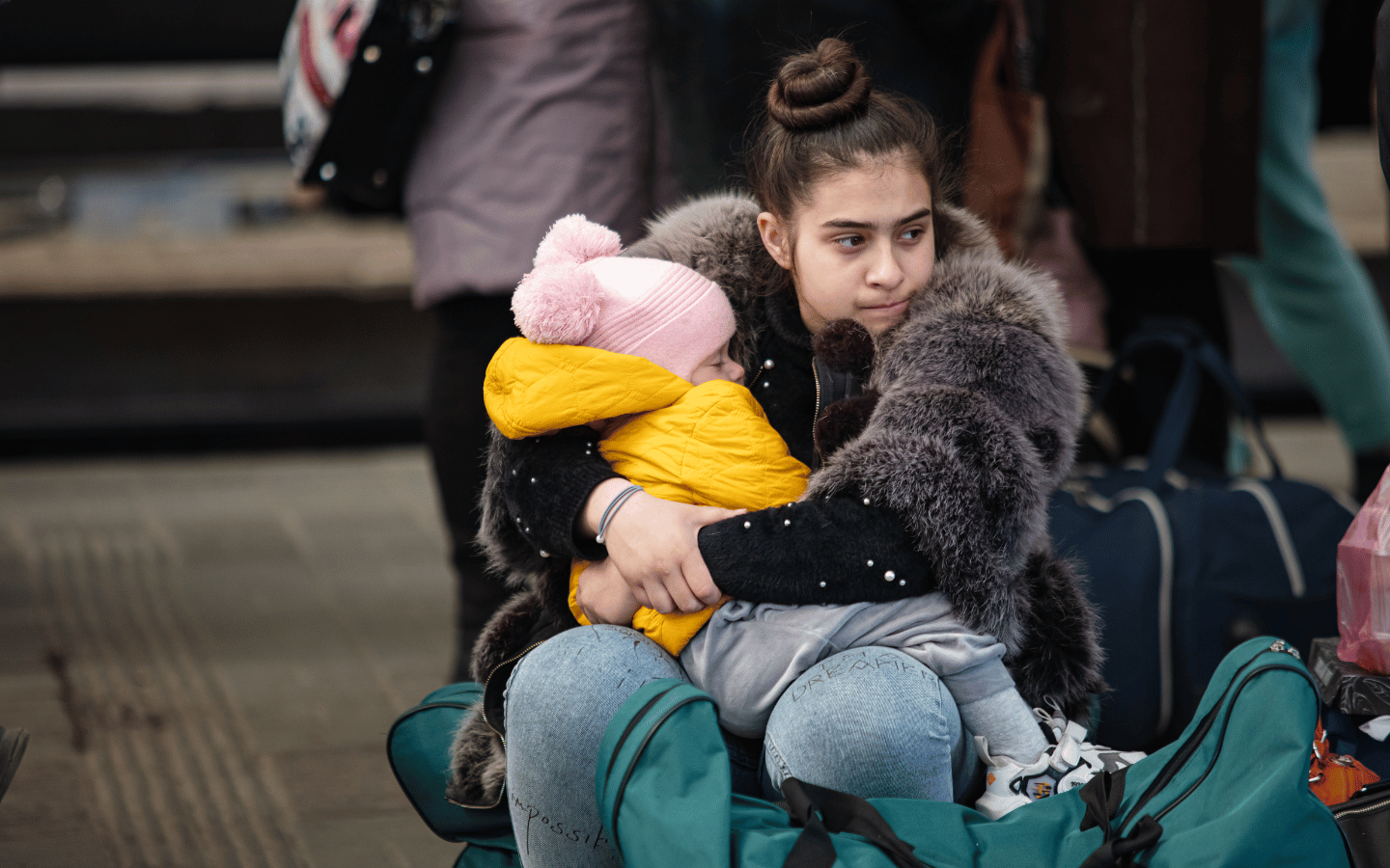 Young Ukrainian refugees wait at a bus station.