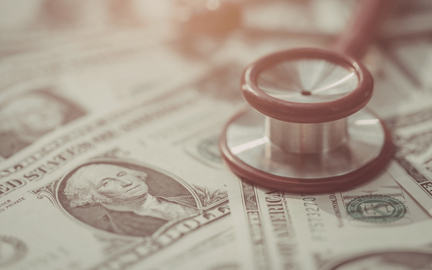 A stethoscope sits on a pile of money.