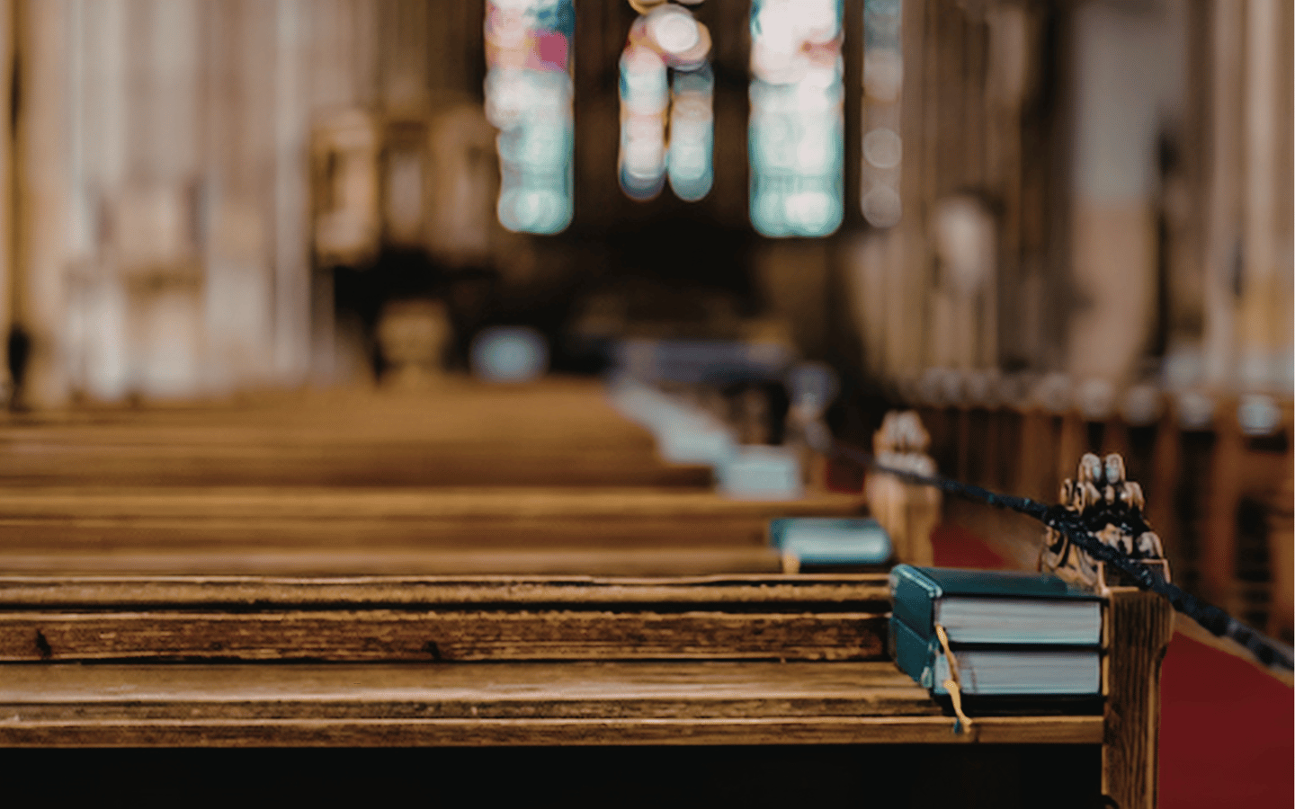 A close-up of a church pew in a sanctuary.