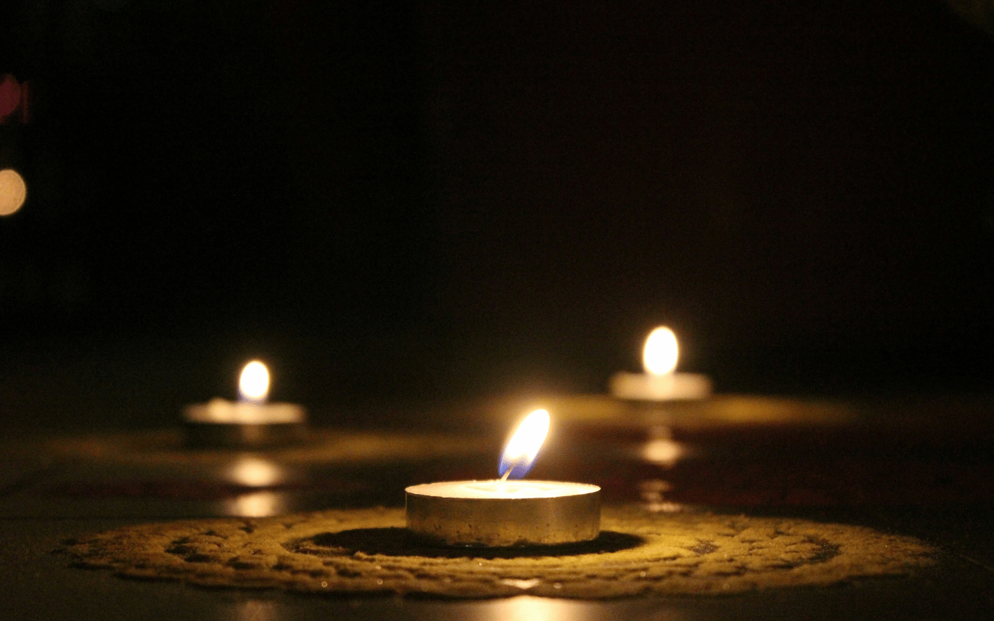 Votive candles sit on a stitched doily.