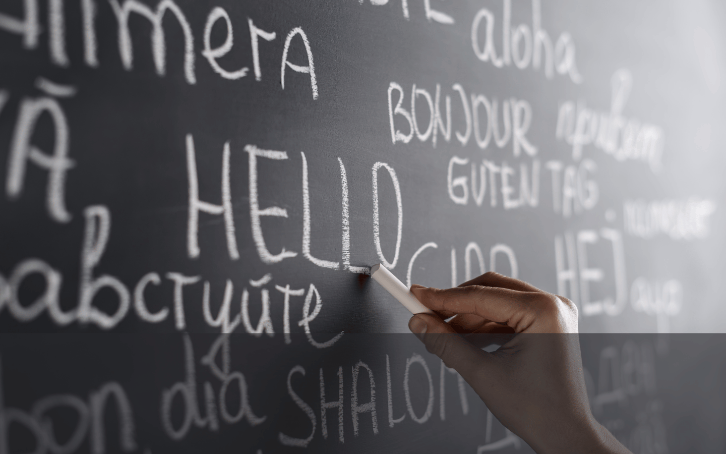 The word “hello” written on a chalkboard in various languages.