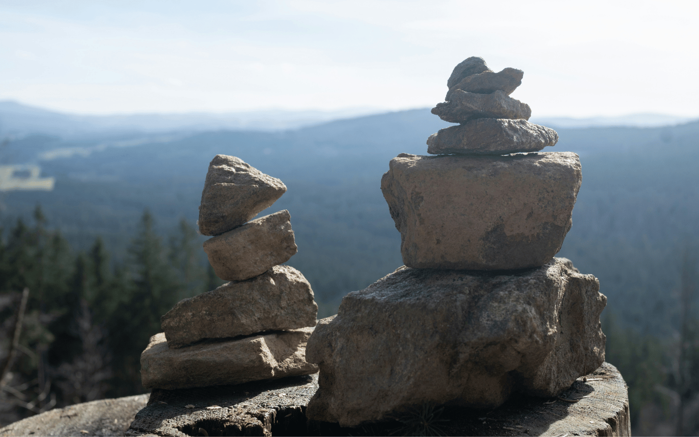 Stones on a ledge are stacked in remembrance.
