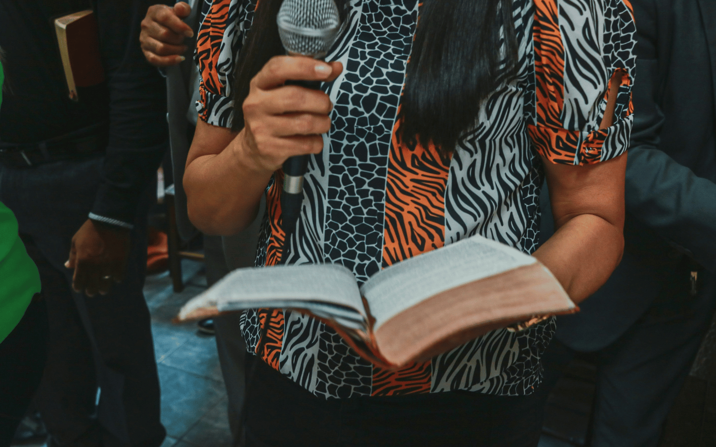 A woman preaches from the Bible.