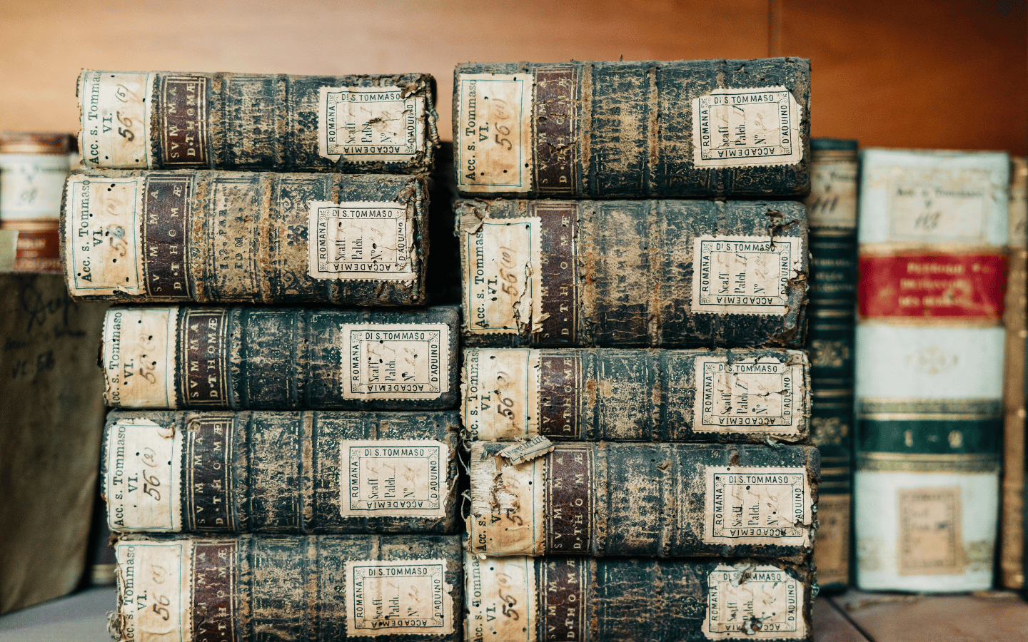 The spines of old volumes of the Summa of Thomas Aquinas.