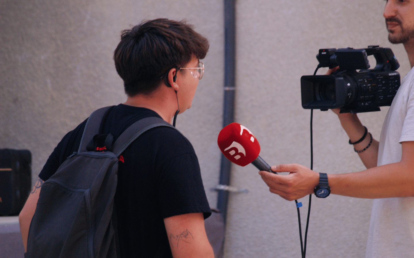 A reporter interviews a man on the street.