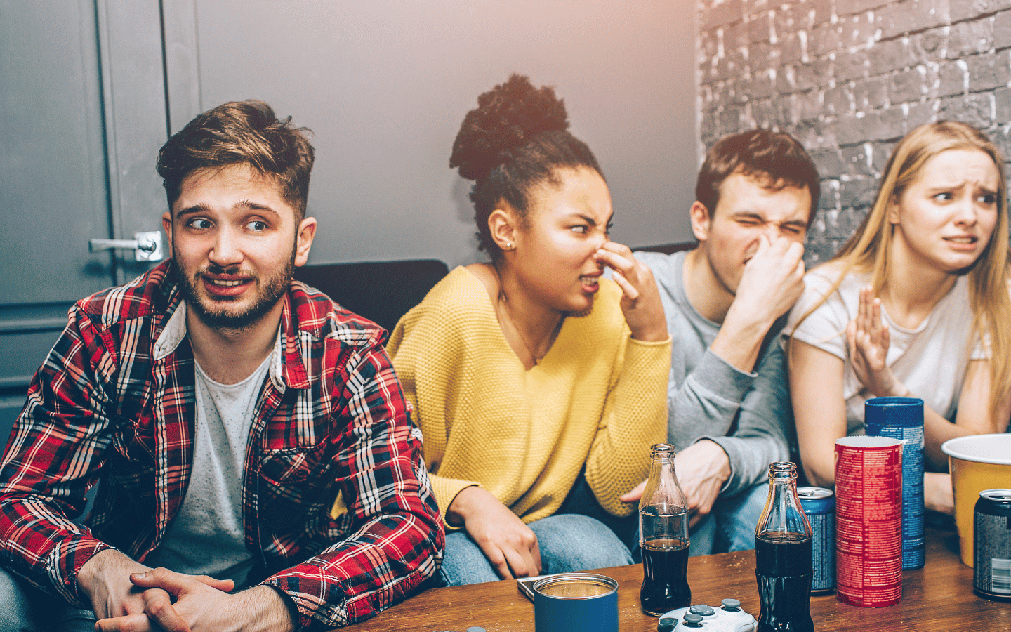 A group of teenagers holds their noses.