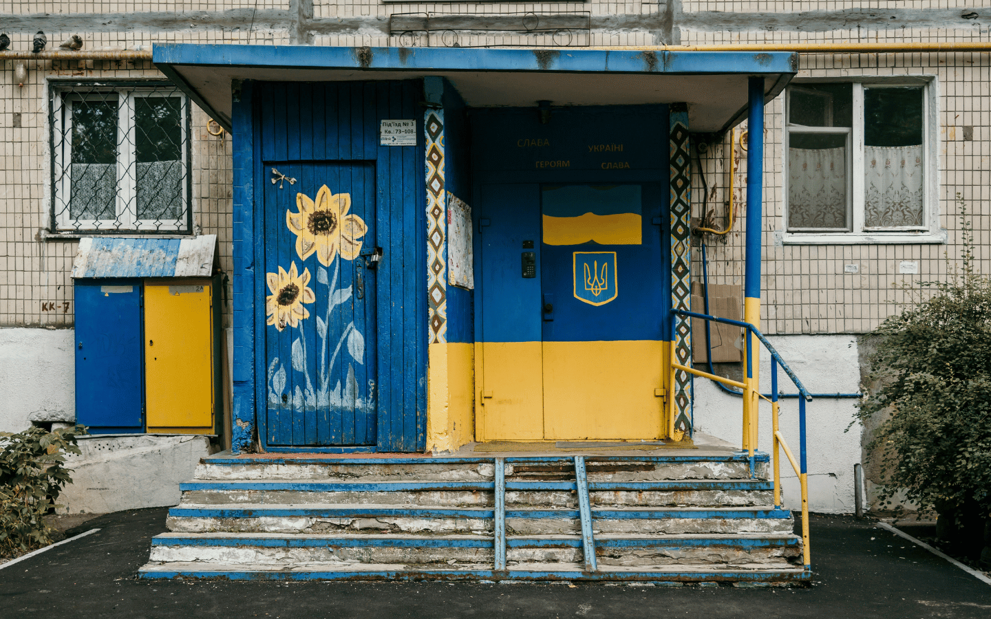 A Soviet-era building in Ukraine with doors painted in the Ukrainian flag colors.